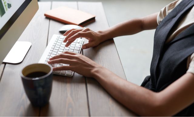 Image d'illustration, femme en train de taper sur son clavier à son bureau